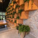 Góc phòng khách phong cách biophilic design với bình sứ Bát Tràng men trắng đặt cạnh cây xanh, ánh sáng tự nhiên