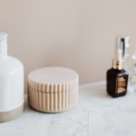 Bộ dụng cụ spa gốm sứ Bát Tràng trắng ngà — bình chiết dung dịch, khay oval, hũ sứ đặt trên bàn massage tone trắng tối giản
