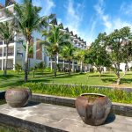 Bộ amenity gốm sứ Bát Tràng men trắng ngà xếp trên khay gỗ tre trong phòng resort ven biển, ánh sáng ban mai tự nhiên