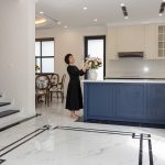 Góc phòng khách phong cách quiet luxury với cốc sứ Bát Tràng men trắng ngà trên khay gỗ sồi, ánh sáng chiều tự nhiên