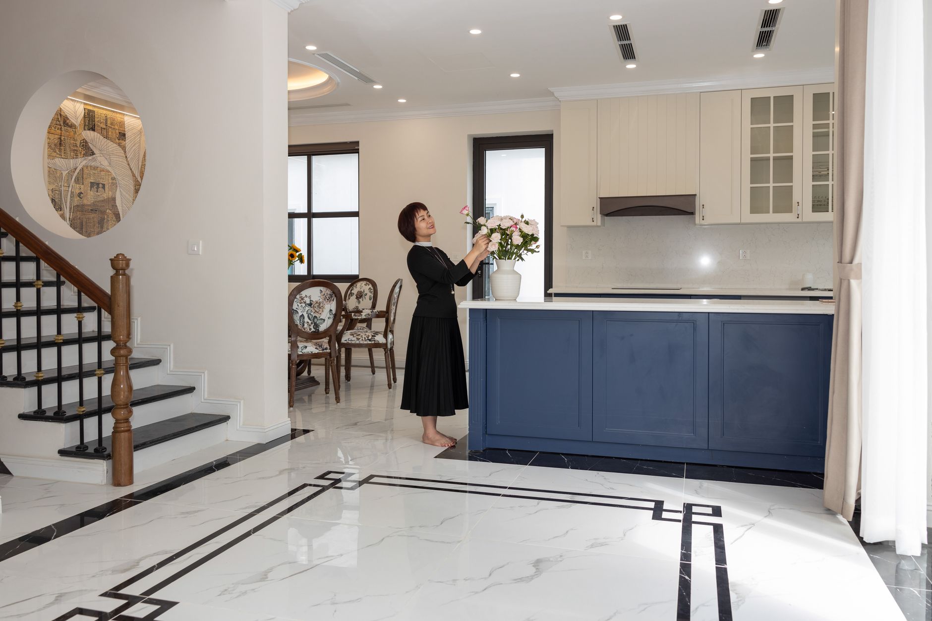 Góc phòng khách phong cách quiet luxury với cốc sứ Bát Tràng men trắng ngà trên khay gỗ sồi, ánh sáng chiều tự nhiên