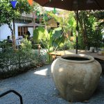 Bộ cốc sứ Bát Tràng Linh Miêu trắng ngà đặt trên quầy pool bar resort nhiệt đới ánh nắng tự nhiên